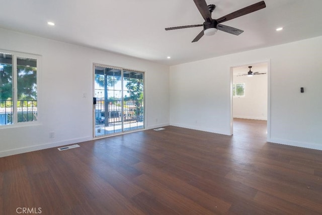 spare room with ceiling fan, a healthy amount of sunlight, and dark hardwood / wood-style floors