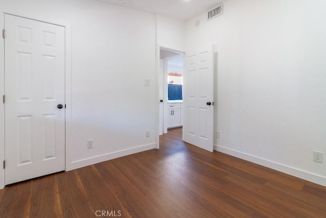 unfurnished bedroom with dark hardwood / wood-style flooring