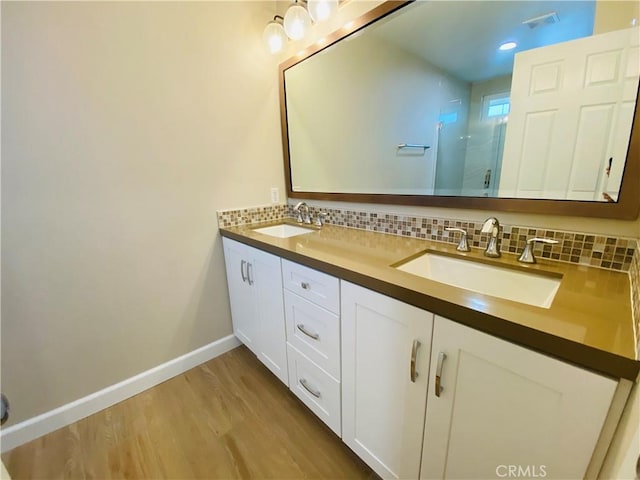 bathroom with vanity, decorative backsplash, a shower with shower door, and hardwood / wood-style flooring