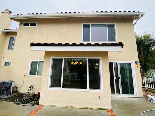 back of property with cooling unit and a patio area