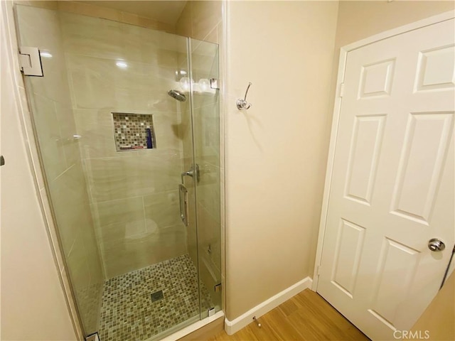 bathroom with hardwood / wood-style floors and walk in shower