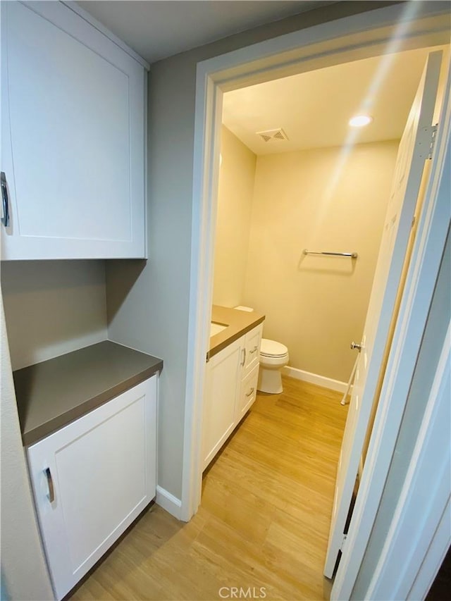 bathroom featuring vanity, hardwood / wood-style floors, and toilet