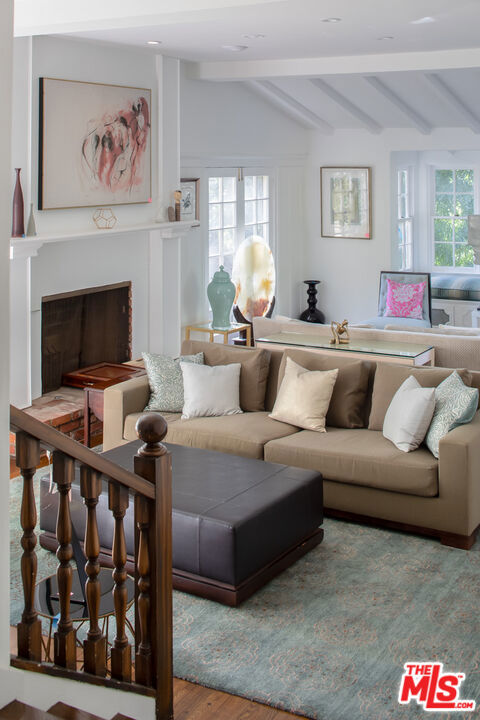 living room with hardwood / wood-style flooring and vaulted ceiling with beams