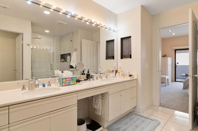 bathroom with vanity, a shower with door, and tile patterned flooring