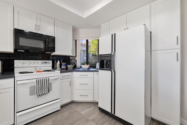 kitchen with white appliances, decorative backsplash, and white cabinets