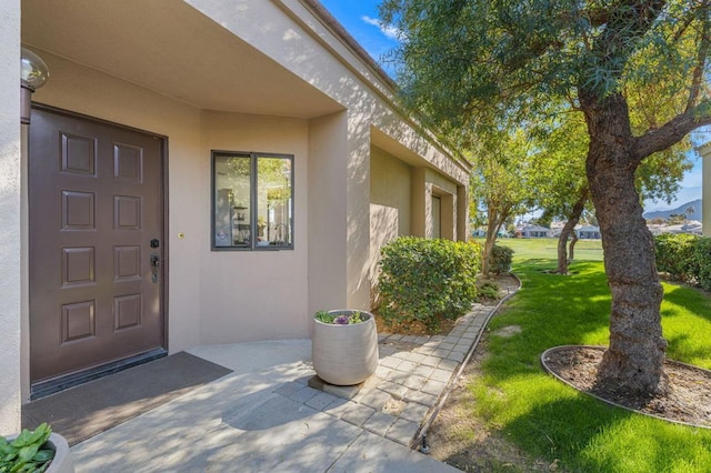 doorway to property with a yard and a patio