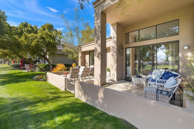 view of exterior entry featuring a yard and a patio area