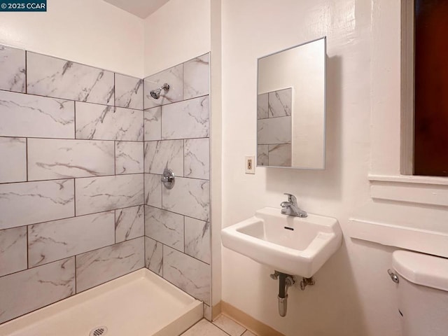 bathroom with tiled shower and toilet