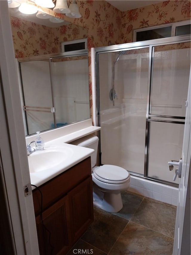 full bath with toilet, wallpapered walls, a shower stall, and vanity