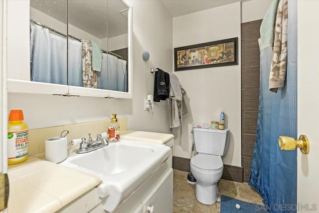 bathroom with vanity, tile patterned flooring, toilet, and walk in shower