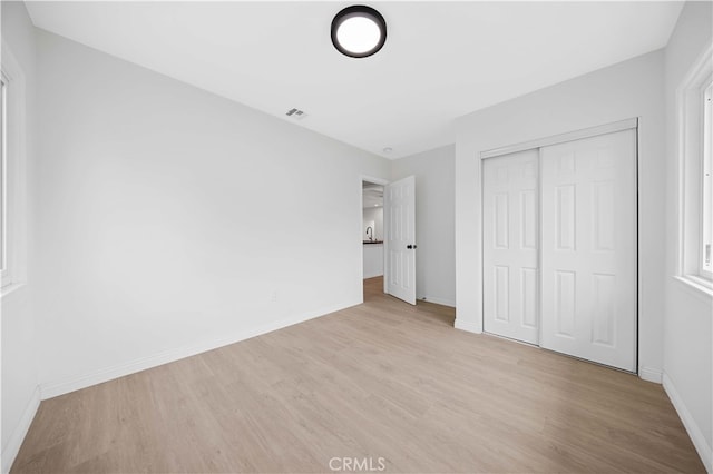 unfurnished bedroom with a closet and light hardwood / wood-style flooring