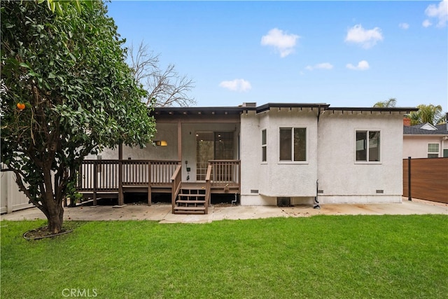 back of house featuring a wooden deck and a lawn