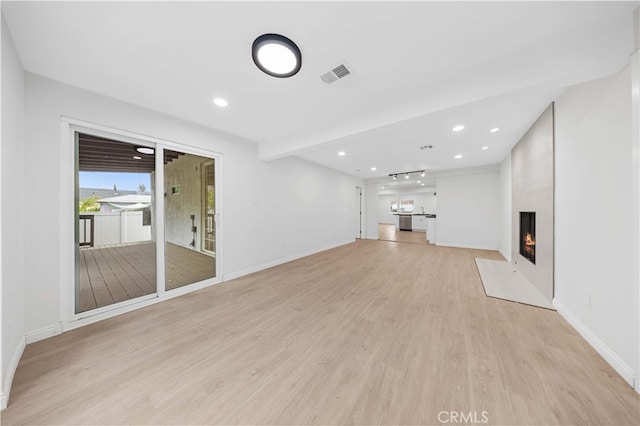 unfurnished living room with a large fireplace and light wood-type flooring