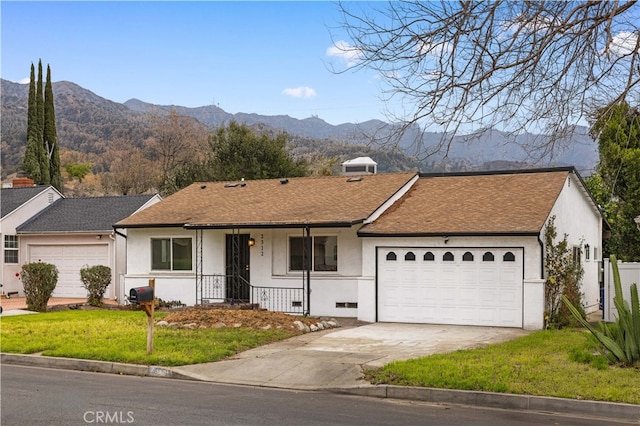 ranch-style home with a garage, a mountain view, and a front yard