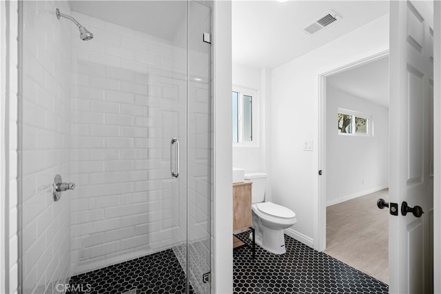 bathroom with walk in shower, vanity, and toilet