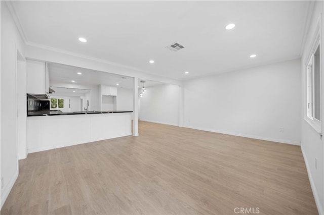 unfurnished living room with sink and light hardwood / wood-style floors