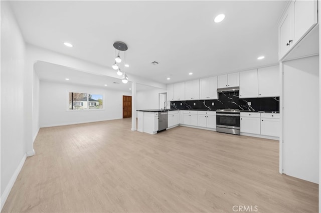 kitchen featuring tasteful backsplash, appliances with stainless steel finishes, decorative light fixtures, and white cabinets