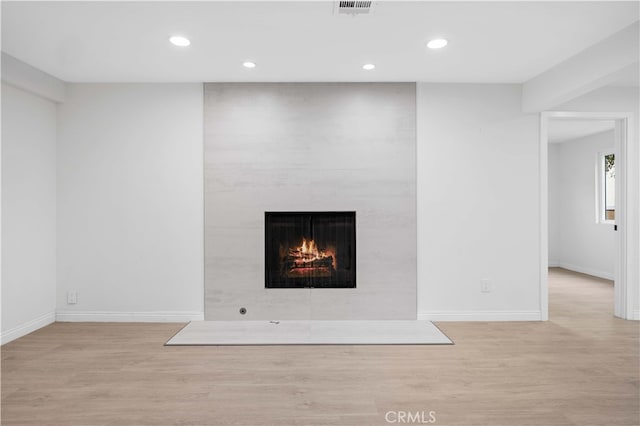 interior details featuring wood-type flooring and a fireplace