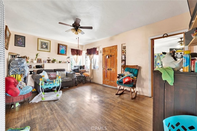 living area featuring wood-type flooring and ceiling fan