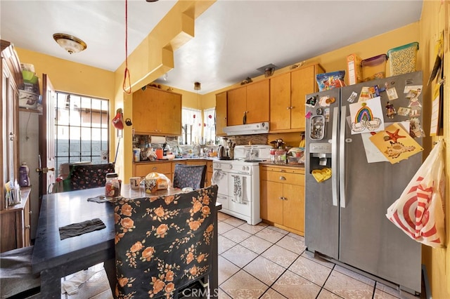 kitchen with stainless steel refrigerator with ice dispenser, light tile patterned floors, and white stove