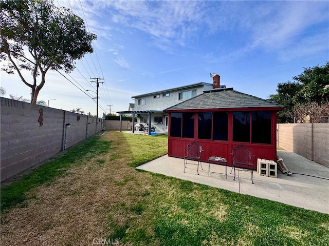 back of house featuring a patio area, a fenced backyard, roof with shingles, and a yard