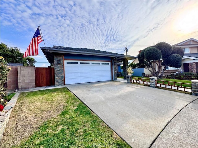 view of front of property featuring driveway, stone siding, fence, and a front lawn