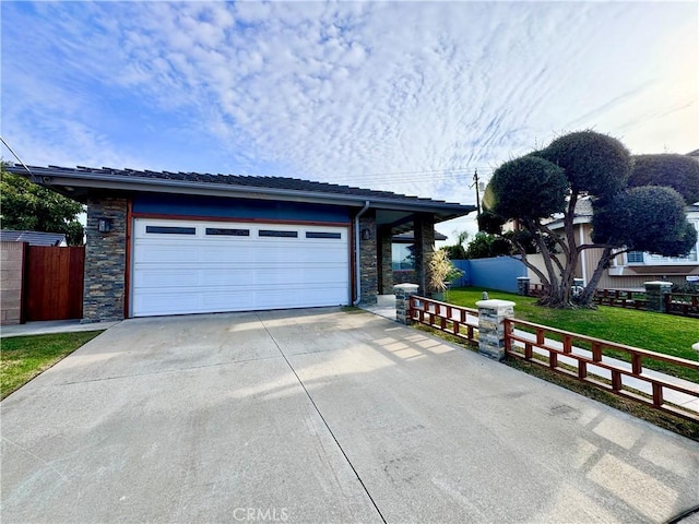 garage featuring driveway and fence