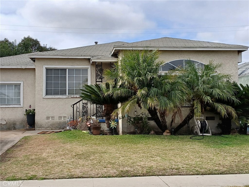 view of front of property featuring a front lawn and stucco siding