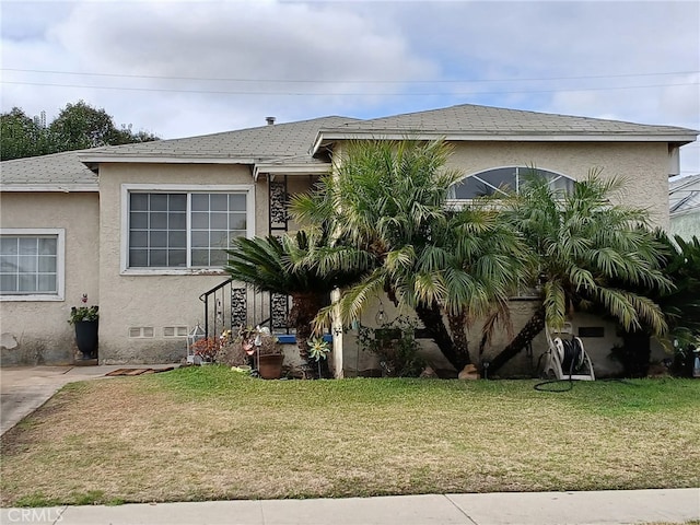 view of front of property featuring a front lawn and stucco siding