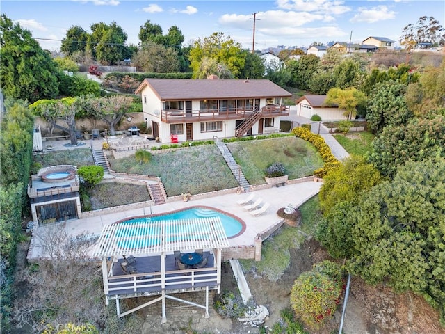 rear view of house featuring a swimming pool with hot tub, a pergola, and a patio area