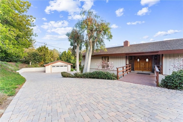 single story home with an outbuilding, a garage, and a porch