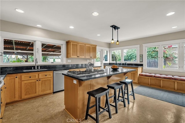 kitchen with a breakfast bar, decorative light fixtures, sink, a center island, and stainless steel appliances