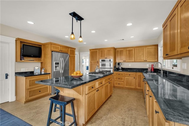 kitchen featuring a kitchen island, a breakfast bar, decorative light fixtures, sink, and stainless steel appliances