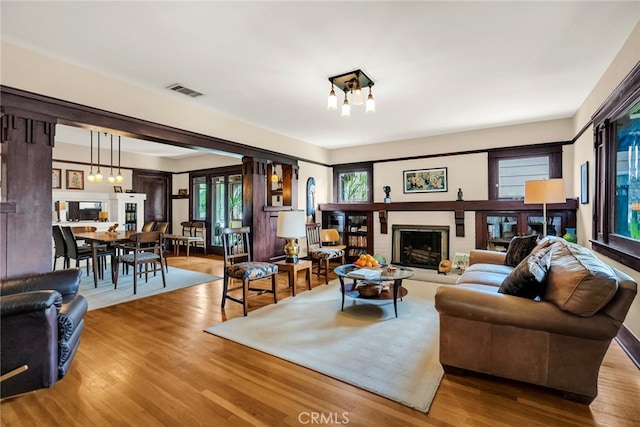 living room with a brick fireplace and wood-type flooring