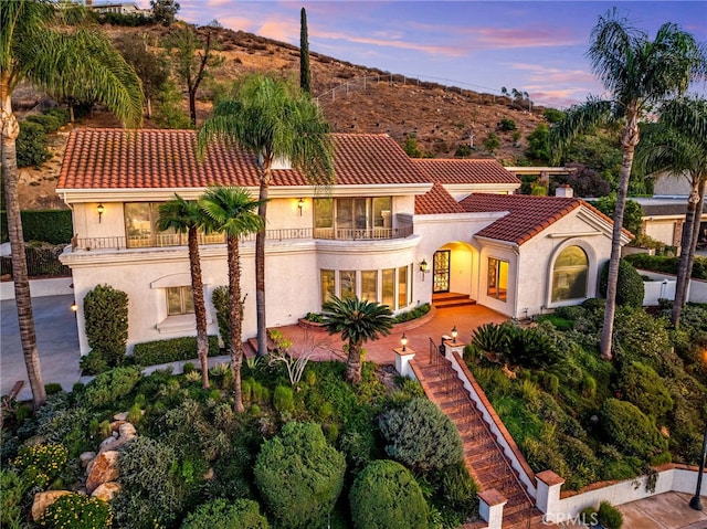 mediterranean / spanish-style house with a patio area and a balcony