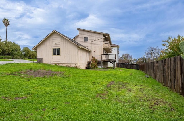 back of property featuring a wooden deck and a lawn