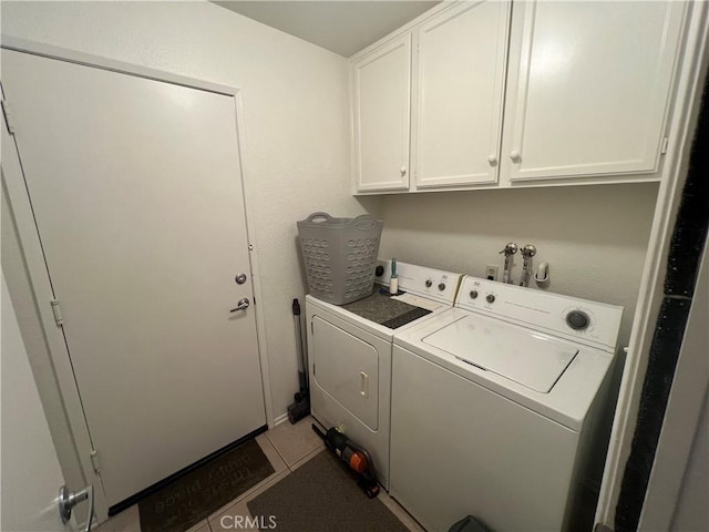 laundry area with cabinets, tile patterned floors, and washer and dryer