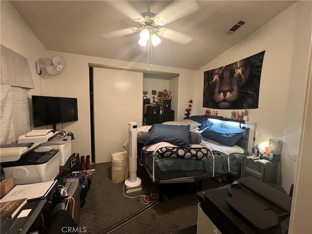 bedroom with vaulted ceiling, carpet, ceiling fan, and a textured ceiling