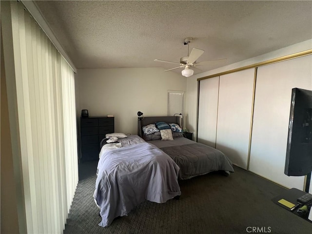 carpeted bedroom featuring ceiling fan, a textured ceiling, and a closet