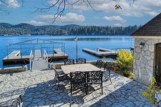 view of patio / terrace featuring a water and mountain view and a boat dock