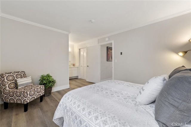 bedroom with crown molding, ensuite bath, and light wood-type flooring