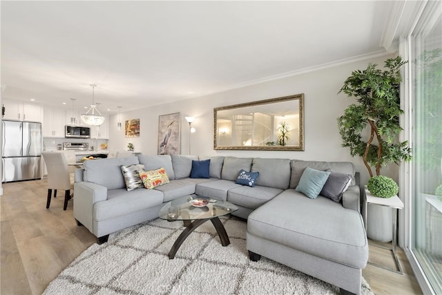 living room with crown molding and light hardwood / wood-style floors