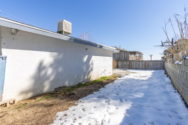 yard layered in snow featuring central air condition unit