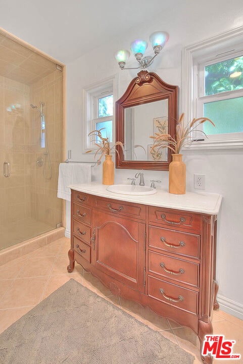 bathroom featuring tile patterned flooring, vanity, and a shower with shower door