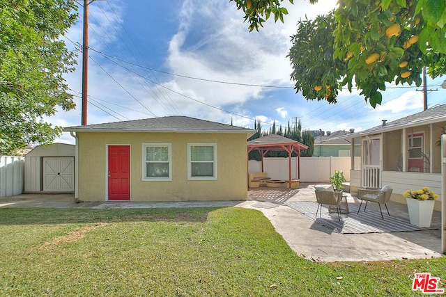 back of property featuring an outdoor living space, a gazebo, a lawn, and a storage unit