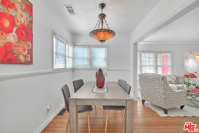 dining room with a wealth of natural light and light wood-type flooring