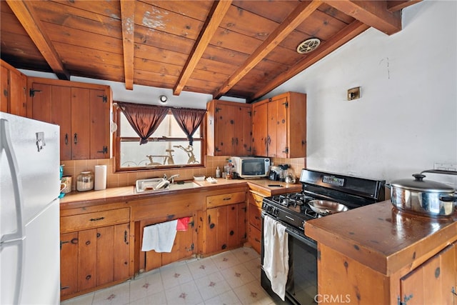 kitchen featuring gas stove, vaulted ceiling with beams, wooden ceiling, white fridge, and backsplash