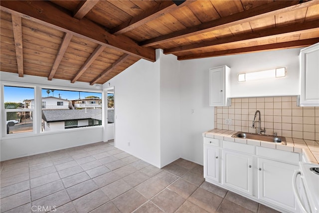 kitchen featuring electric stove, sink, tasteful backsplash, white cabinets, and tile countertops