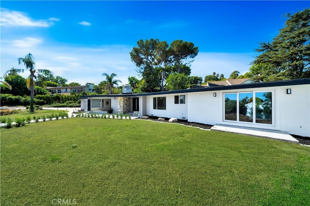 rear view of property with a lawn