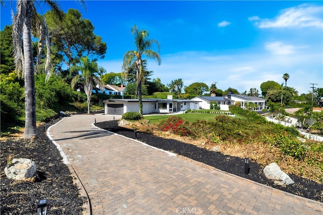 ranch-style house featuring a garage and a front yard